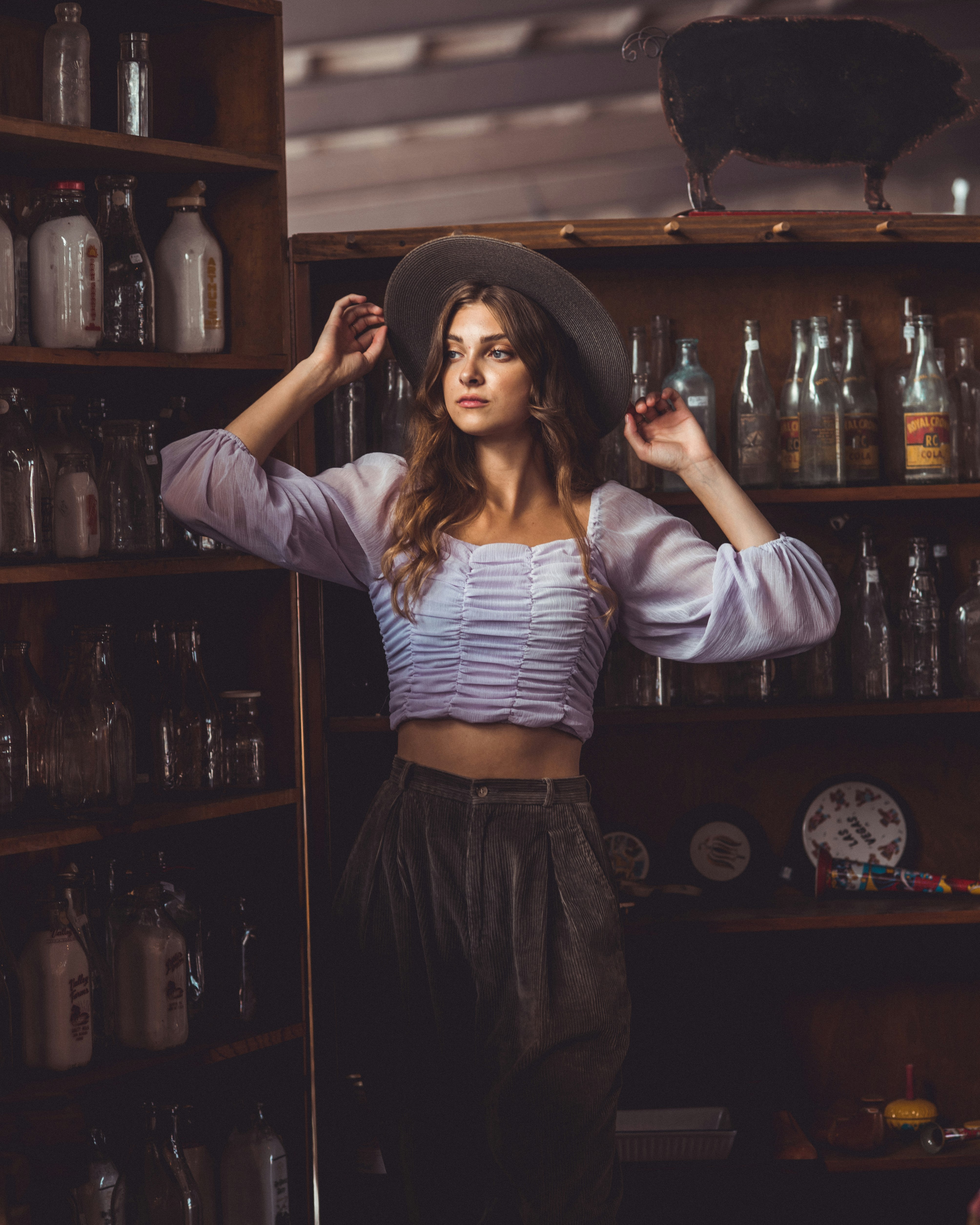 woman in white long sleeve shirt and blue denim skirt holding bottle